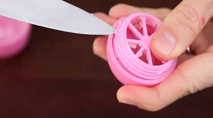 If you're refilling the EOS lip balm container, just unscrew it and pop out the middle piece using a knife. And take that piece we just popped out from the base and screw it into the lid.